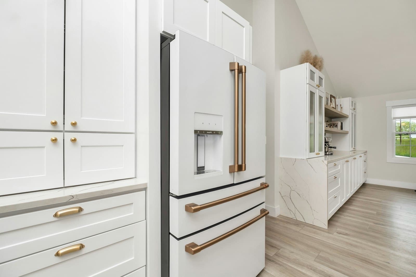Refinished white kitchen cabinets with brass hardware